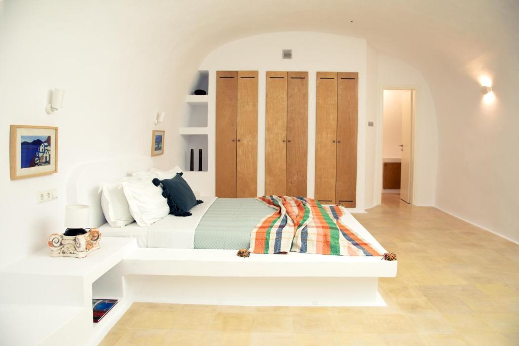 a white bedroom with a bed in a room at Amphora Villas Santorini Akrotiri in Akrotiri