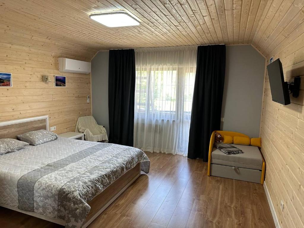 a bedroom with a bed and a television in it at Carpathian Dream Apartments in Yaremche