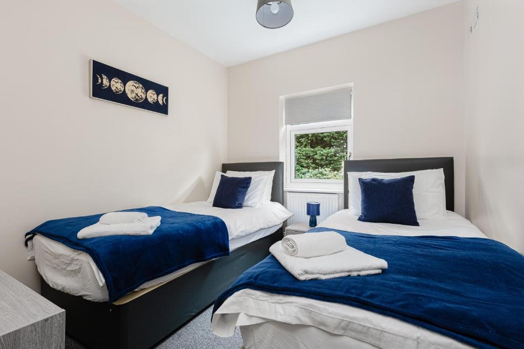 2 letti in una camera con blu e bianco di Norris - Parking Wi-Fi Contractors a Preston