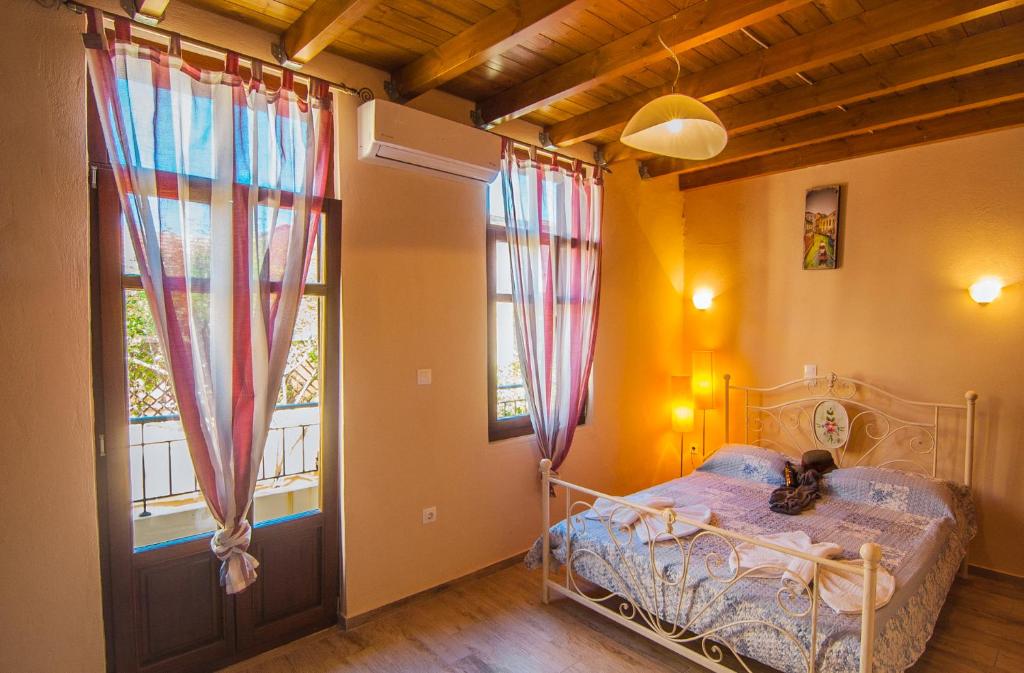 1 dormitorio con cama y ventana en Asikiko Suites, en Rethymno