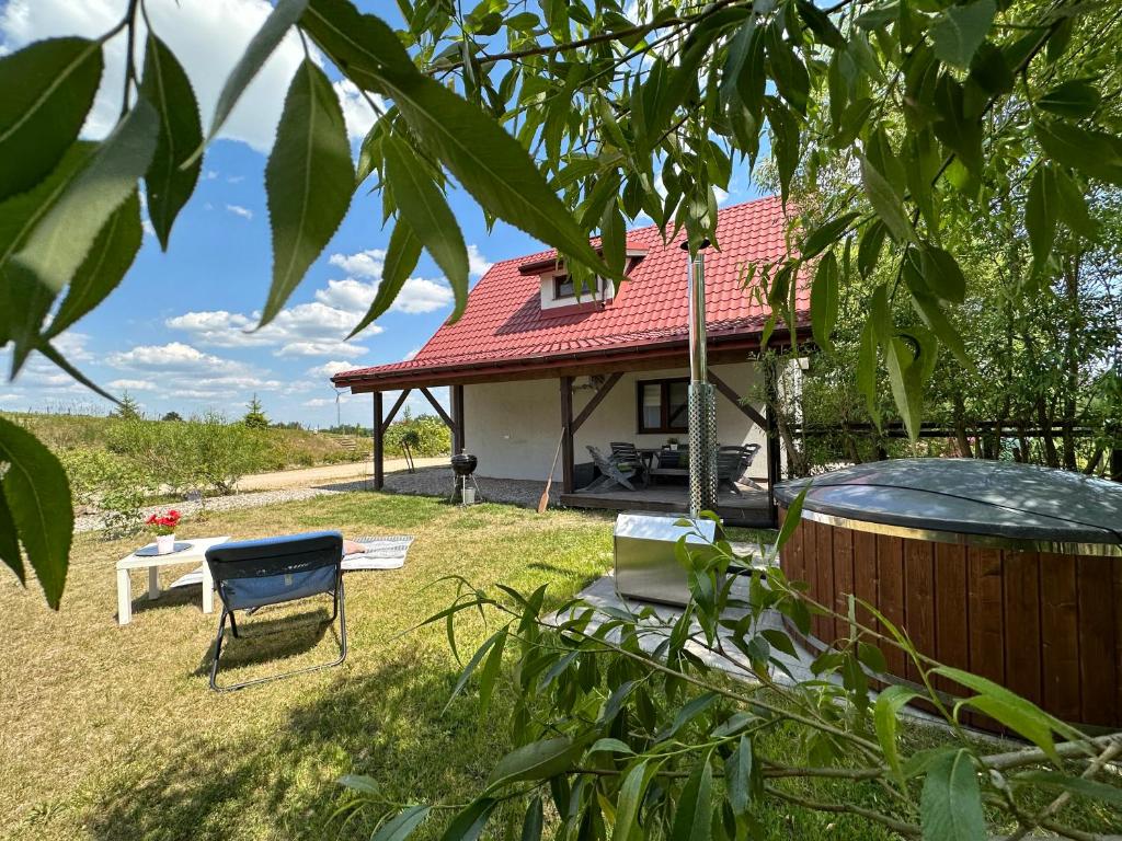 a house with a hot tub in the yard at Szarejkowe Wzgórza in Szarejki