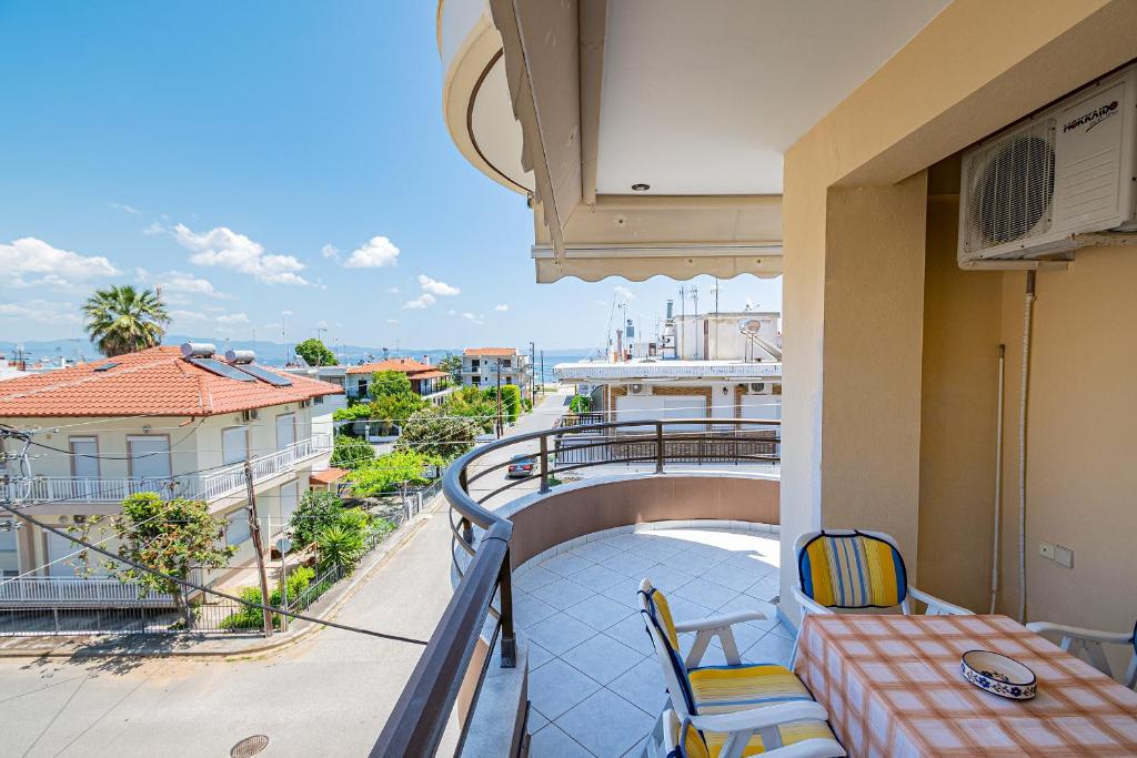 a balcony with a table and chairs on a building at Anastasia Sea View by RentalsPro Services - Nea Potidaia Halkidki in Nea Potidaea