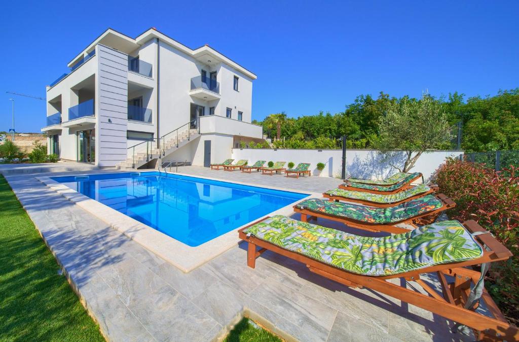 una villa con piscina y una casa en Apartments Paola & Karla with pool, en Krk