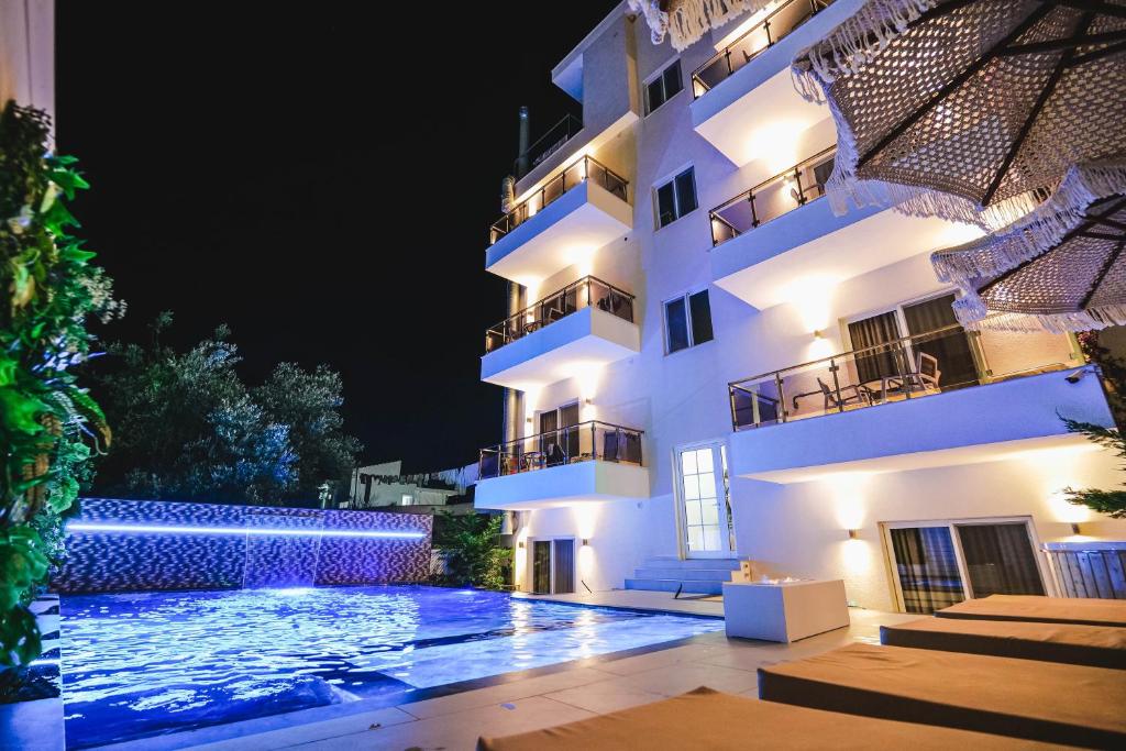 a building with a swimming pool at night at Hotel Mare in Ksamil