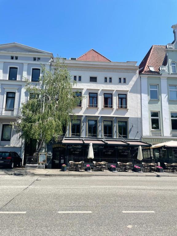 budynek ze stołami i parasolami po stronie ulicy w obiekcie Ferienwohnungen am Holstentor w Lubece