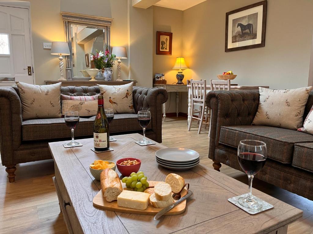 una sala de estar con copas de vino y una mesa con comida en Campden Place - 2 Bed Home in Central Chipping Campden, en Chipping Campden