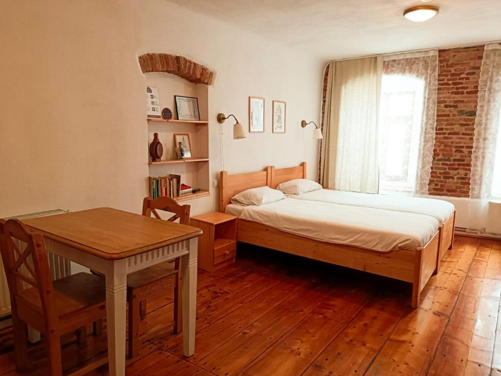 una camera con letto, scrivania e tavolo di Heltau Apartments a Cisnădie