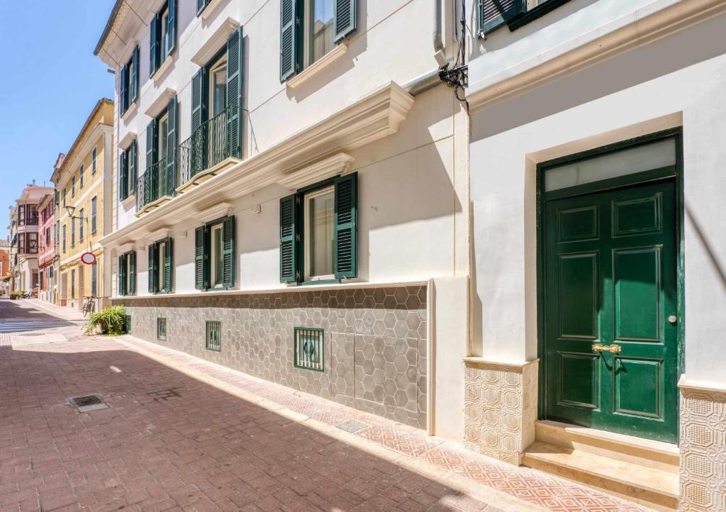 a building with a green door on a street at Casa Turqueta in Mahón