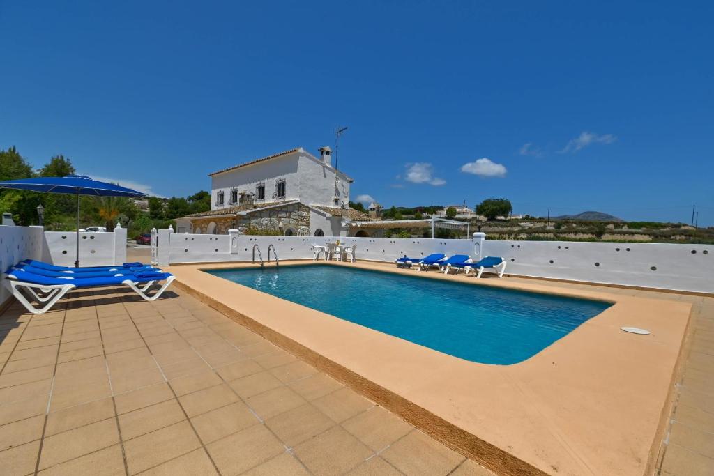 a swimming pool with lounge chairs and an umbrella at Abiareta in Jávea