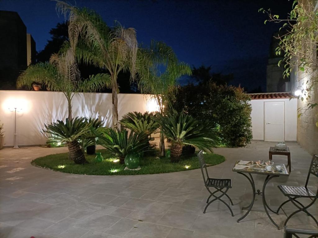 un giardino notturno con palme e luci di Il Giardino della Scuncerta a Lecce