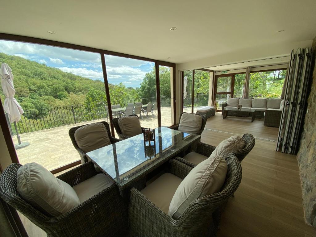 sala de estar con mesa de cristal y sillas en Las Terrazas de Chilla, en Candeleda