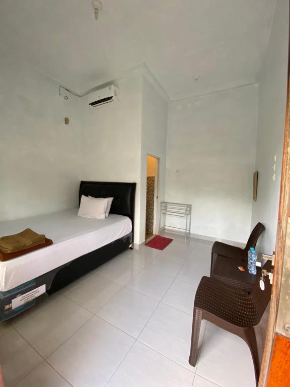 a bedroom with a bed and a chair at Bara Village Guest House Bira in Bira