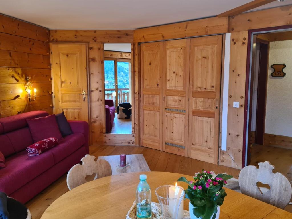 a living room with a red couch and a table at Le Bristol - Villars Bristol Apartments in Villars-sur-Ollon