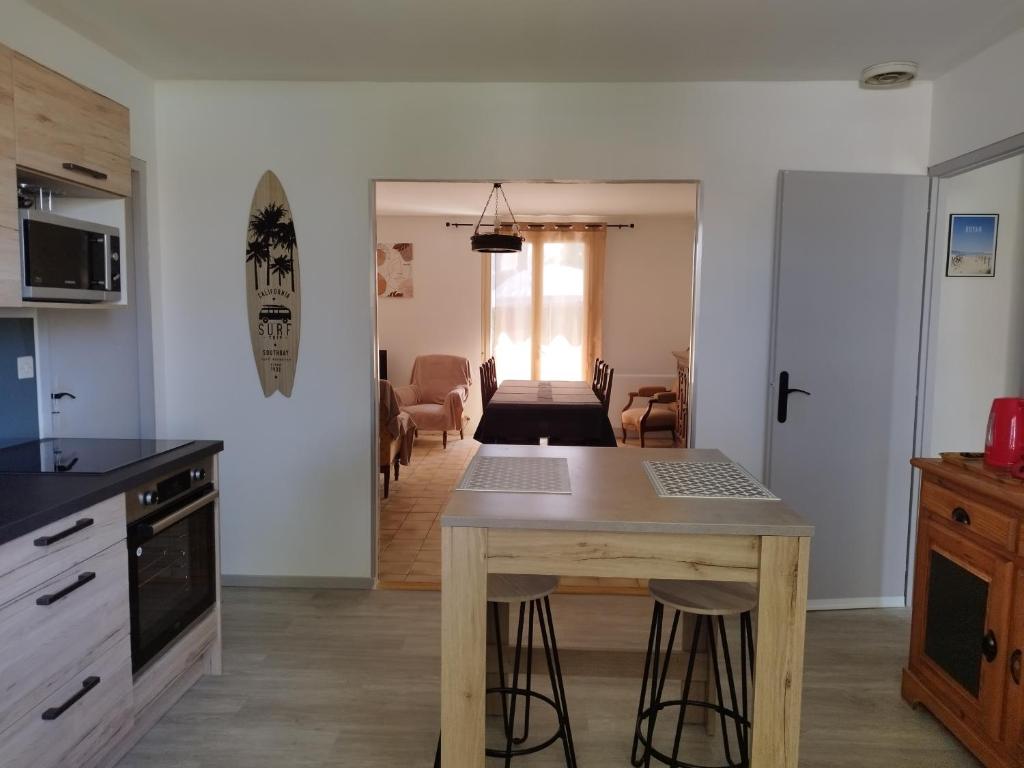 une cuisine avec une table et un salon dans l'établissement maison la garenne, à Royan