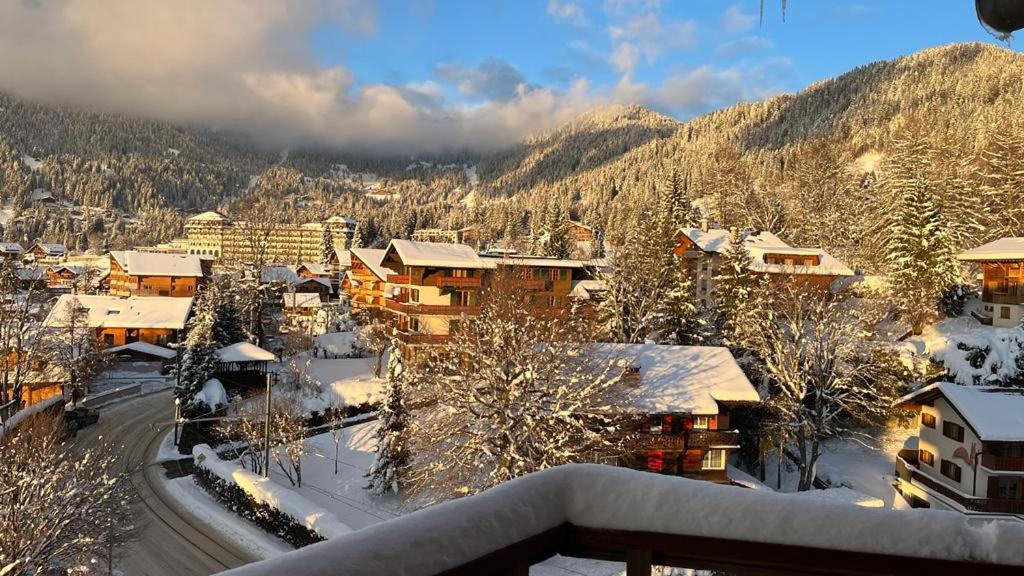 a town with snow covered buildings and a mountain at Le Bristol - Villars Bristol Apartments in Villars-sur-Ollon
