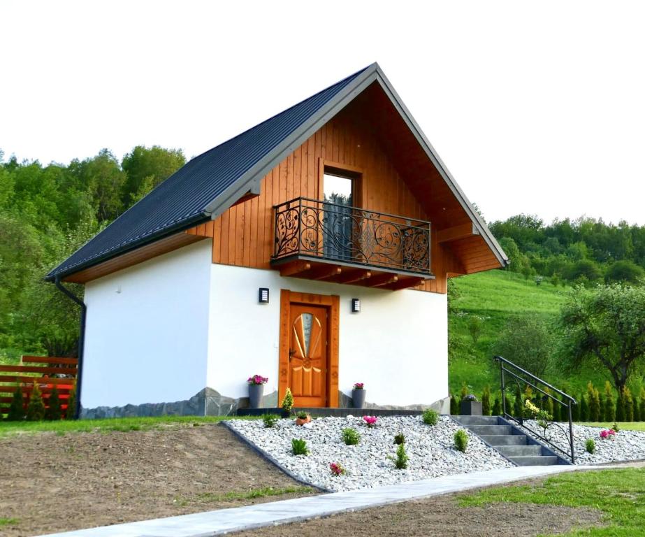 a small house with a balcony on top of it at Domek przy Lubaniu in Ochotnica Dolna