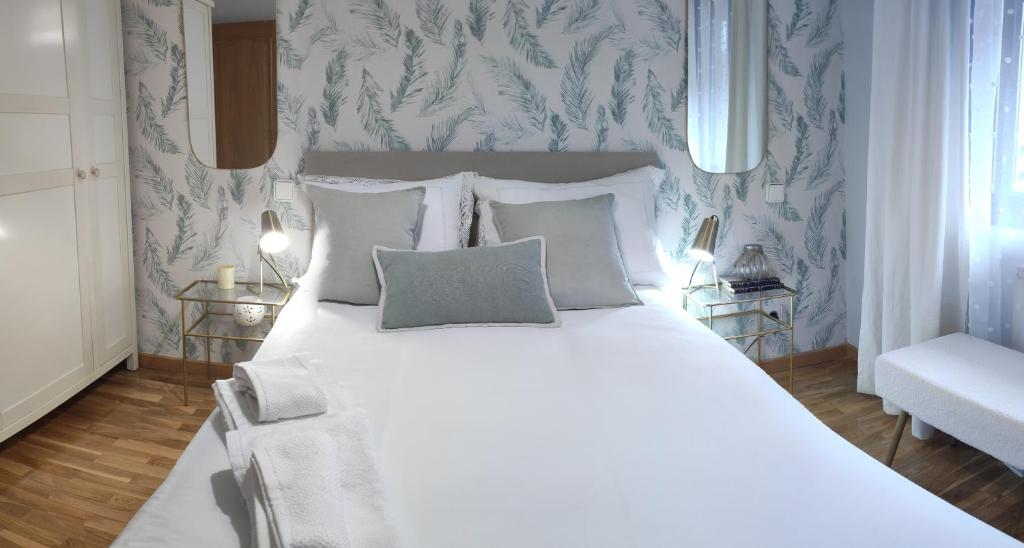 1 dormitorio con 1 cama blanca grande y papel pintado de color azul en LA ERMITA en Zamora