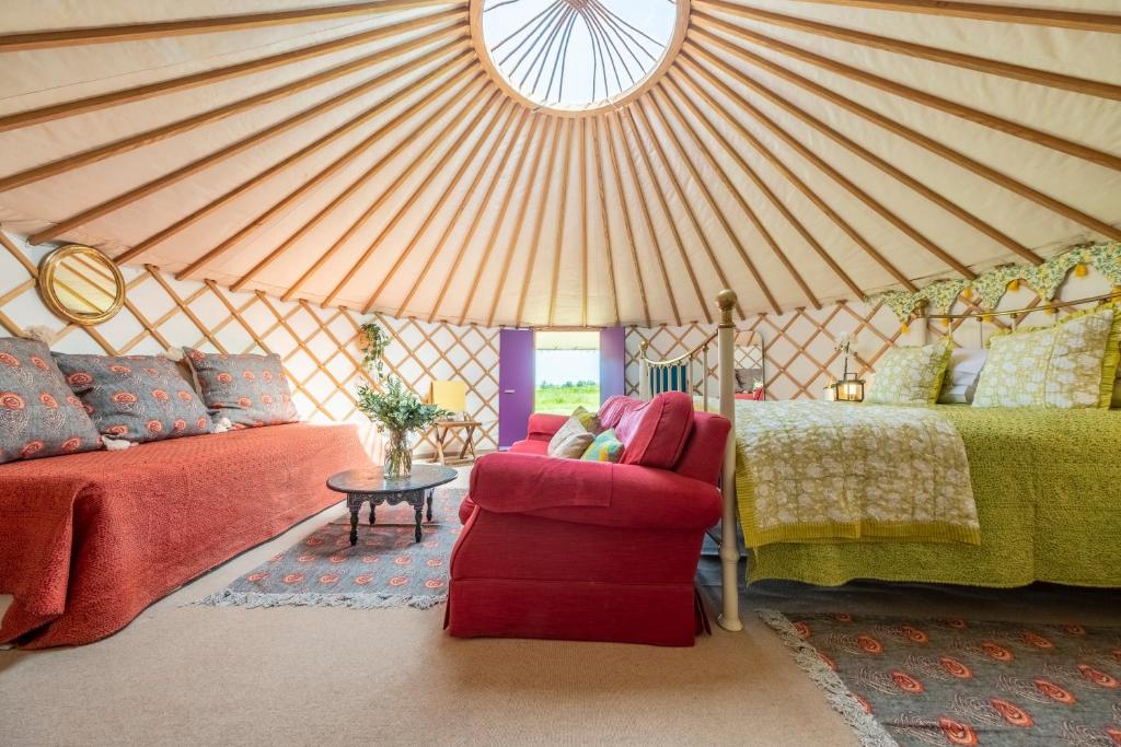 a yurt with a bed and a couch and a chair at Luxury glamping in Constable Country - Valley View Yurt 