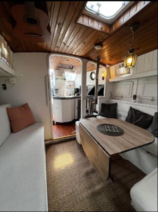 a living room with a couch and a table in a rv at Bateau Watson, vivez l'aventure in Ouistreham