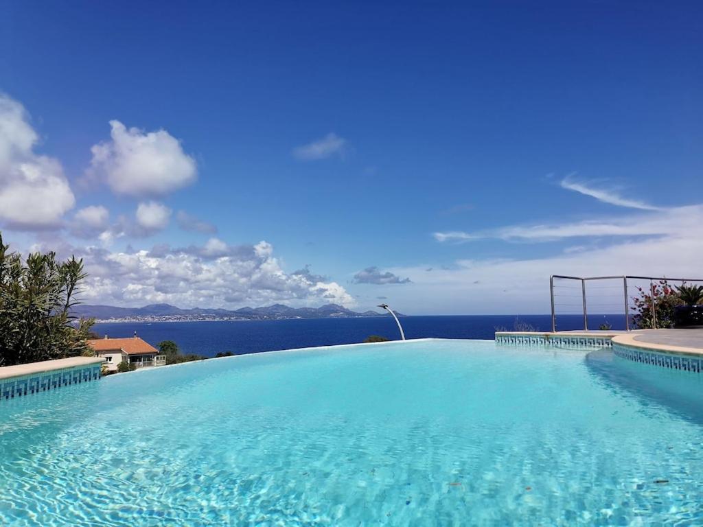 une grande piscine avec vue sur l'océan dans l'établissement Rez de villa vue mer et sa piscine privative à débordement, à Saint-Peïre-sur-Mer