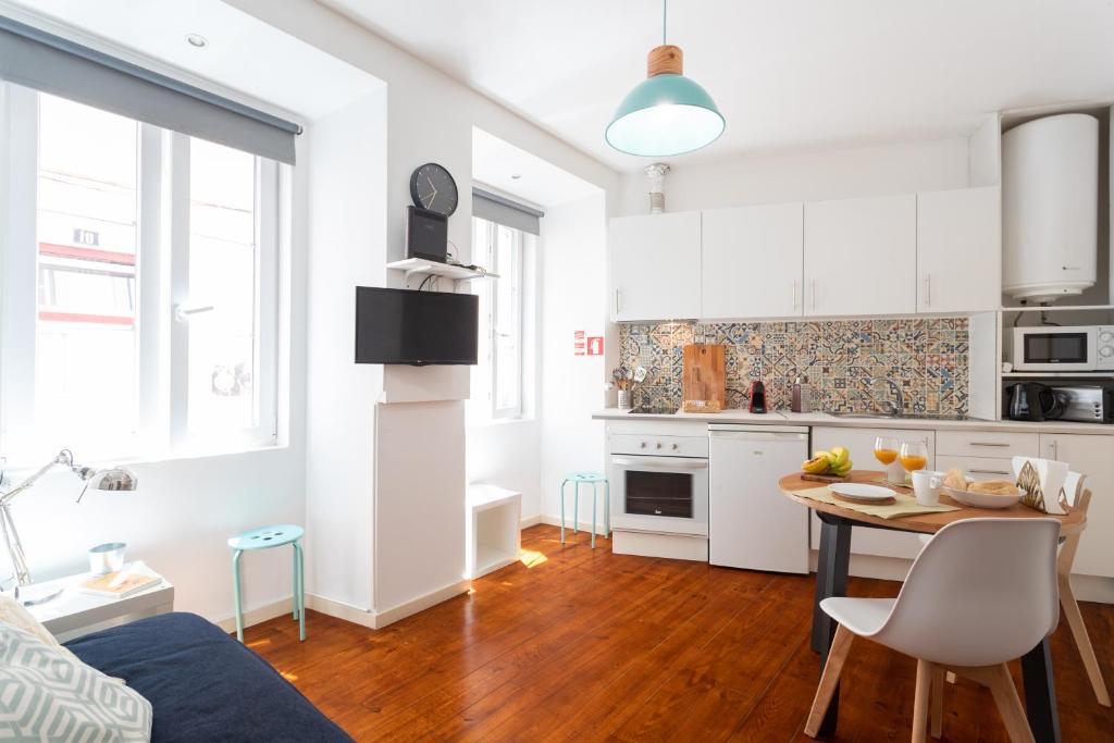 a kitchen and a living room with a table at Lisbon Mouraria Apartment in Lisbon
