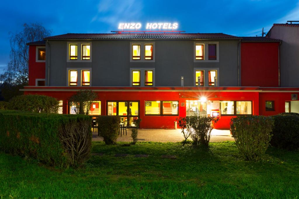un hotel con un edificio rojo y gris en Enzo Hotels Pont-a-Mousson by Kyriad Direct, en Pont-à-Mousson