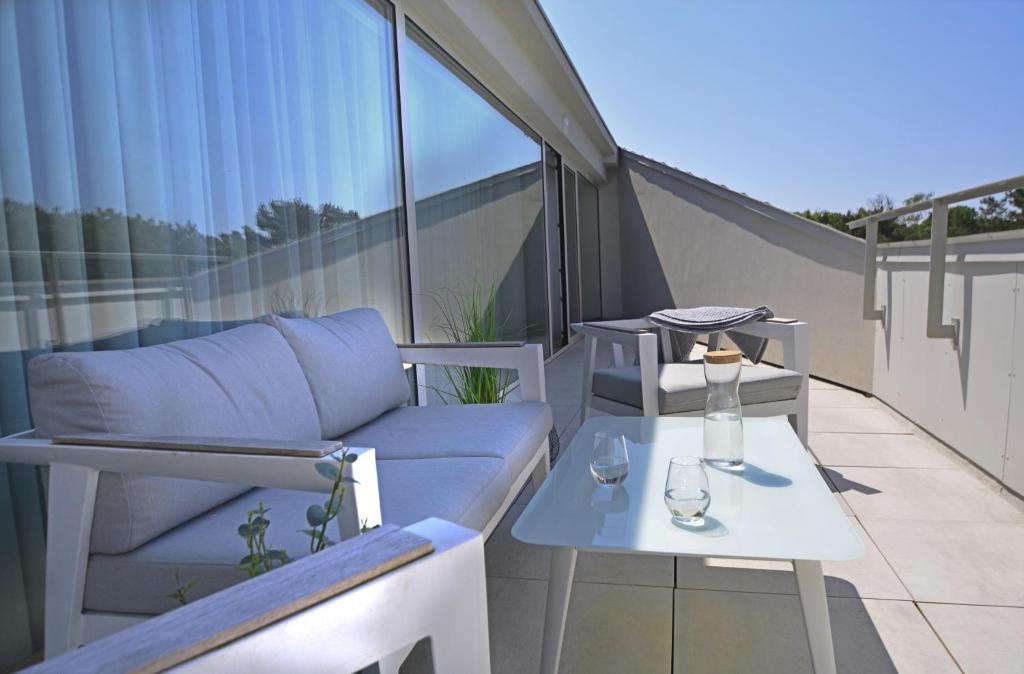 a balcony with a couch and a table on a balcony at Apartamenty Bryza-Baltycki - Apartamenty przy plaży z parkingiem in Świnoujście
