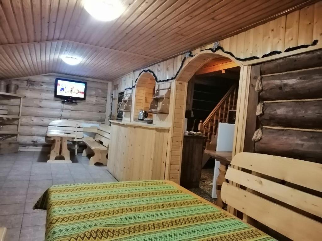 Zimmer mit einem Tisch und einem TV in einer Hütte in der Unterkunft Stara Khata Карпати in Scheschory