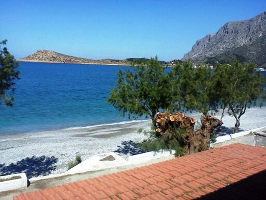 a view of a beach with trees and the water at Argo Studios in Myrties