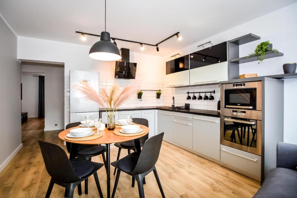 a kitchen and dining room with a table and chairs at Podtatrzańskie Apartamenty in Nowy Targ