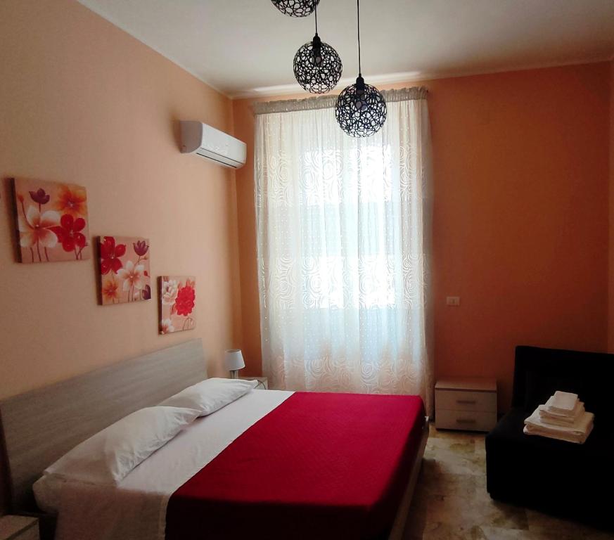 a bedroom with a red and white bed and a window at Arte Mia B&B in Reggio Calabria