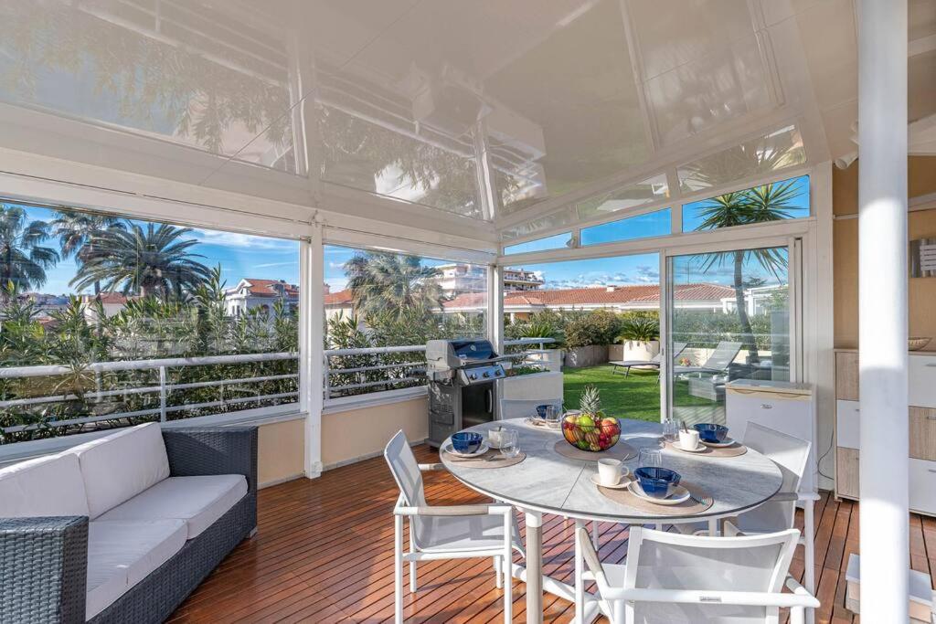un grand salon avec une table et des chaises dans l'établissement Superbe Appartement avec Piscine et Toit Terrasse, à Cannes