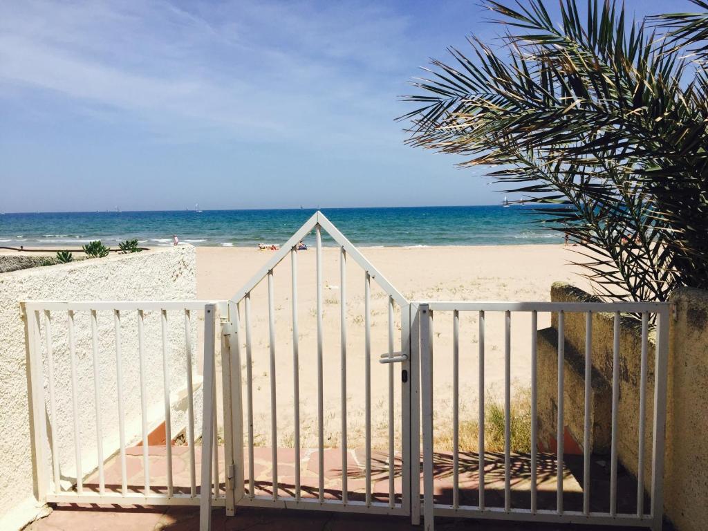 una puerta blanca que conduce a una playa con el océano en Casa Playa Valencia, en El Perelló
