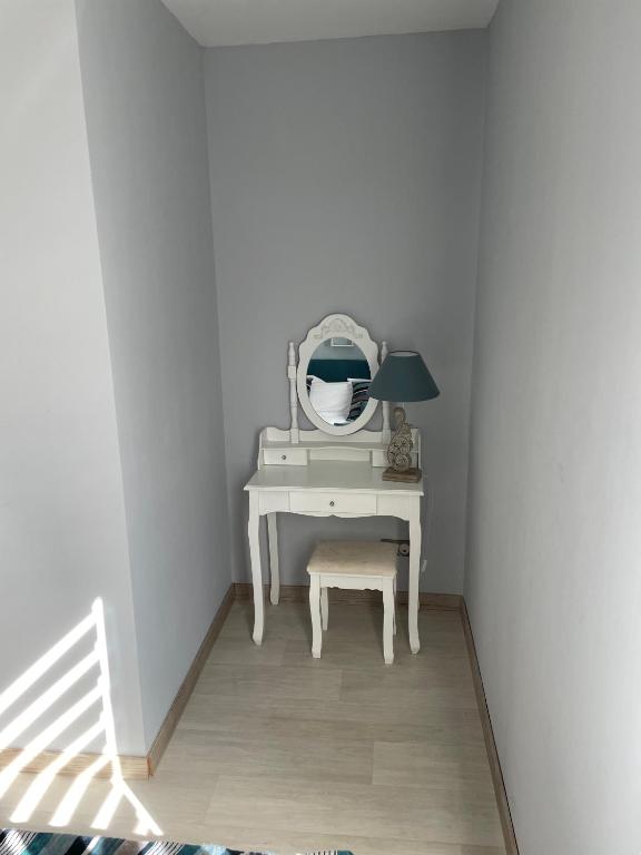 a white dressing table with a mirror and a stool at La Maison de l&#39;Auzette in Limoges