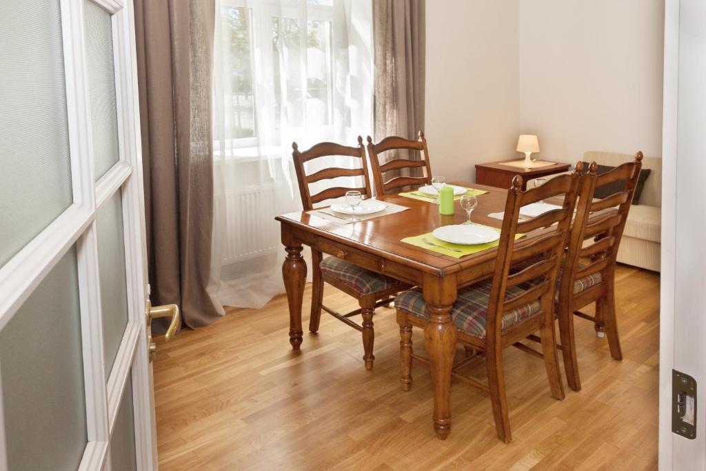 a dining room with a wooden table and chairs at Vytauto apartamentai in Palanga