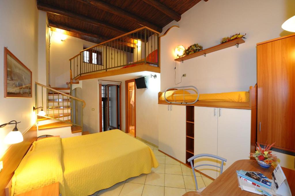 a bedroom with a yellow bed and a staircase at MeFra Camere - Amalfi Coast in Atrani