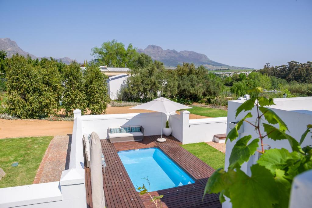 Blick auf den Hinterhof einer Villa mit Pool in der Unterkunft Sunset Farm Stellenbosch in Stellenbosch