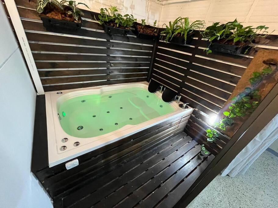 a jacuzzi tub in a room with plants at Descanso y Confort in Medellín