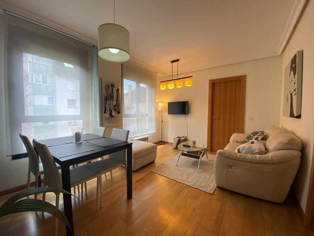 un soggiorno con tavolo e divano di Oviedo Soja City apartamento a minutos del centro a Oviedo