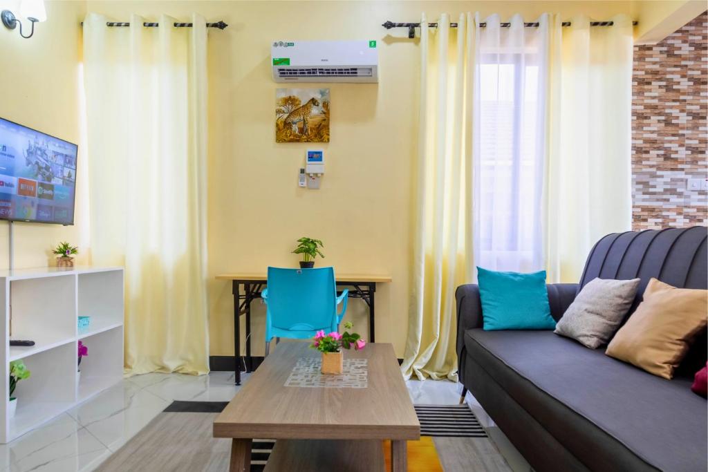 a living room with a couch and a table at City Gem by Havana Properties near the French Embassy, Tanzanite Bridge & Coco Beach in Dar es Salaam