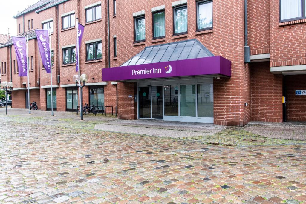 a brick building with a purple sign on it at Premier Inn Braunschweig City Centre in Braunschweig