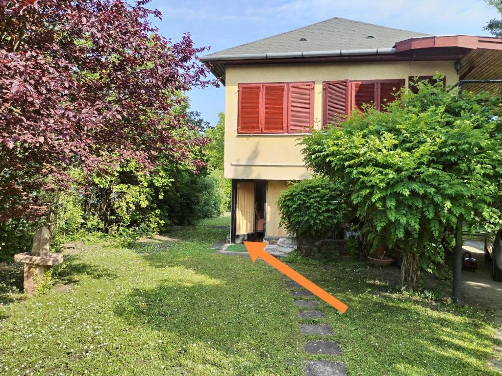 a yard with a house with an orange arrow in it at SeeYou Apartman Agárd in Agárd