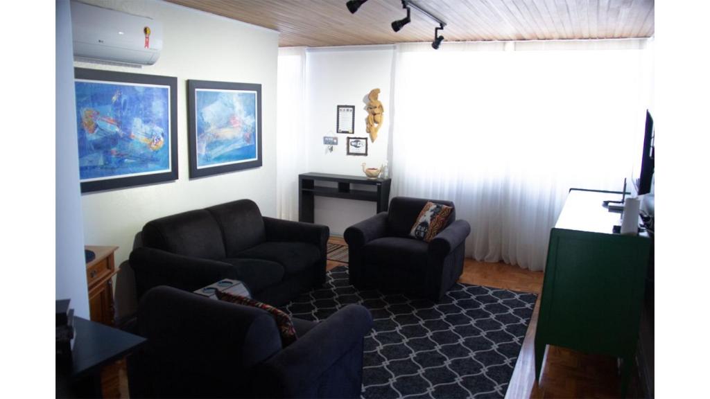 a living room with two chairs and a television at Apto Confortável e Completo em São Pelegrino 22 in Caxias do Sul
