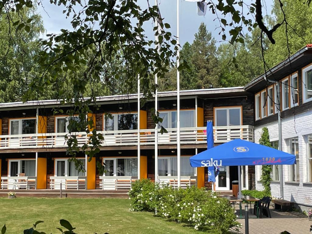 a building with a blue umbrella in front of it at Vaibla Holiday Center in Vaibla