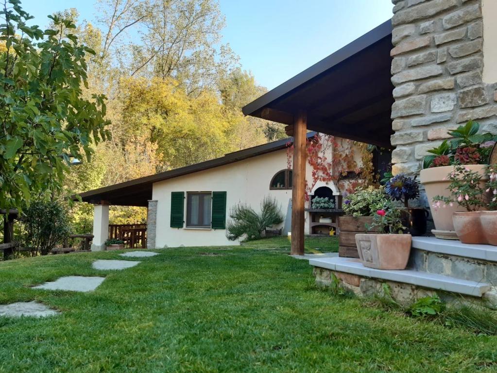 a backyard with a stone house with a black awning at La Lacia in Acqui Terme