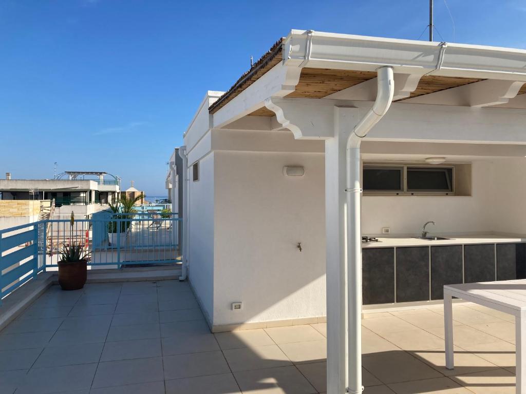 uma varanda com uma cozinha e uma porta aberta em La Fanciulla - Rooftop Apartment em Leuca