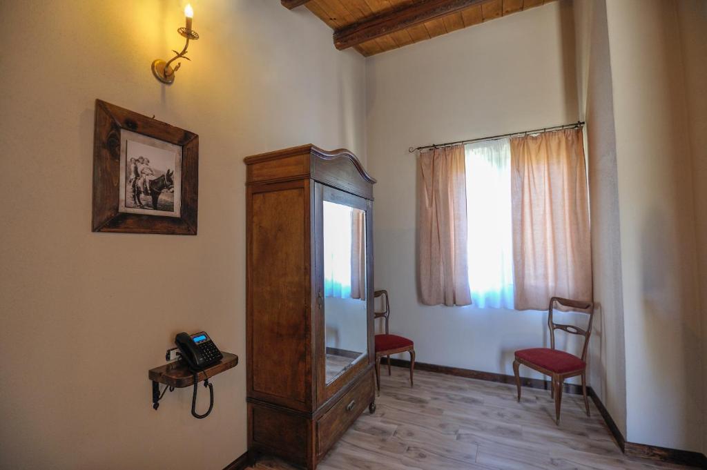 une chambre avec un miroir, deux chaises et une fenêtre dans l'établissement Sorella - Agriturismo-La Fattoria di San Francesco, à Pietraperzia