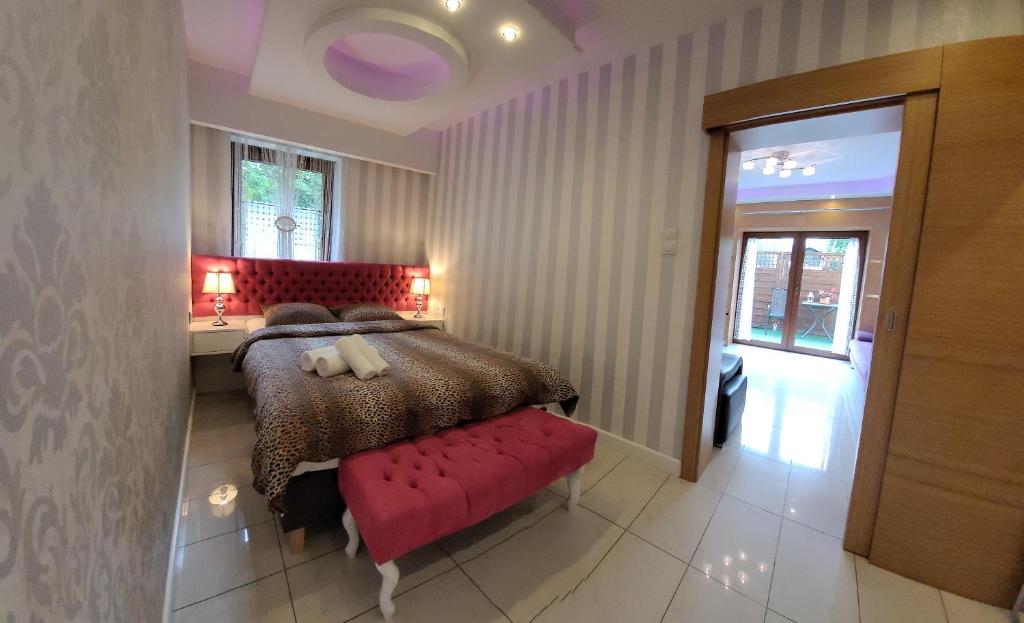 sypialnia z czerwonym łóżkiem i czerwoną ławką w obiekcie Apartament Asenata Ustroń Centrum dwupokojowy parter w Ustroniu