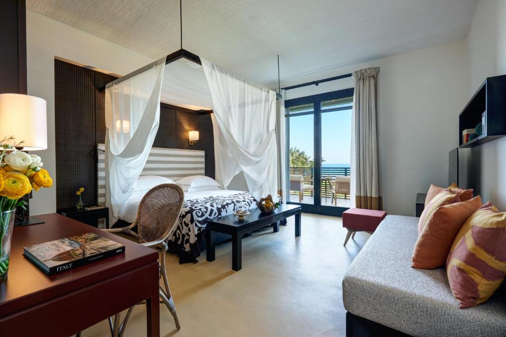 a bedroom with a bed and a living room with a couch at Verdura Resort in Ribera