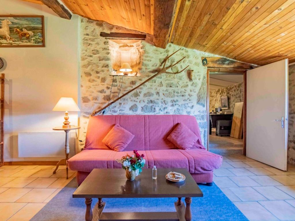 a living room with a pink couch and a table at Holiday Home Le Cèdre - RSB100 by Interhome in Roche-Saint-Secret